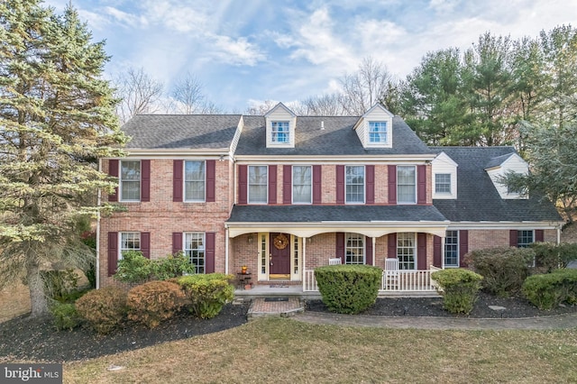 194 Troutman Rd, Collegeville, PA 19426 - colonial house featuring brick siding, roof with shingles, a front yard, and a porch