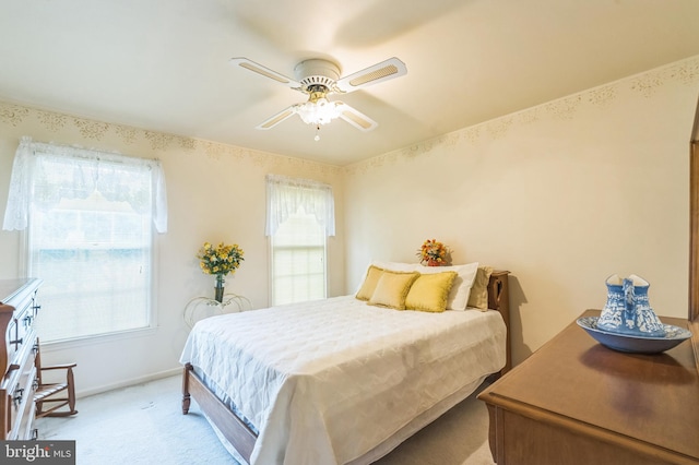 bedroom with ceiling fan and light carpet