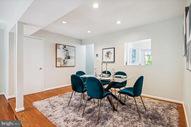 dining area with baseboards, wood finished floors, and recessed lighting