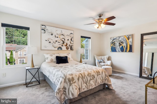 carpeted bedroom featuring ceiling fan, multiple windows, and baseboards