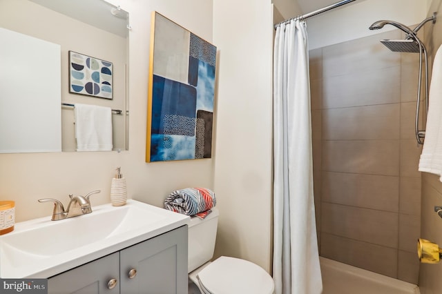 bathroom with curtained shower, vanity, and toilet