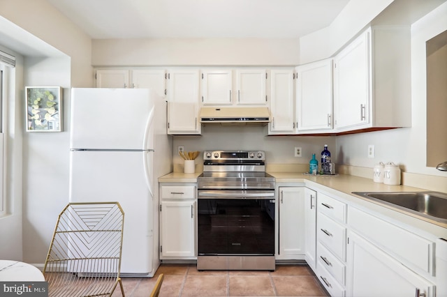 kitchen with under cabinet range hood, white cabinetry, electric stove, light countertops, and freestanding refrigerator