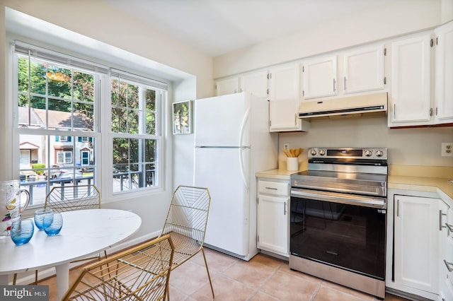 kitchen with under cabinet range hood, electric range, white cabinets, light countertops, and freestanding refrigerator