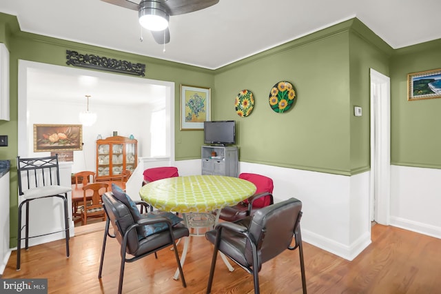 dining room featuring wood-type flooring, ornamental molding, and ceiling fan