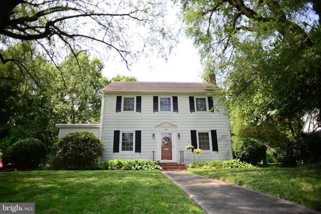 colonial-style house featuring a front lawn