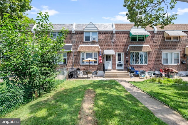 multi unit property featuring a patio area and a front lawn