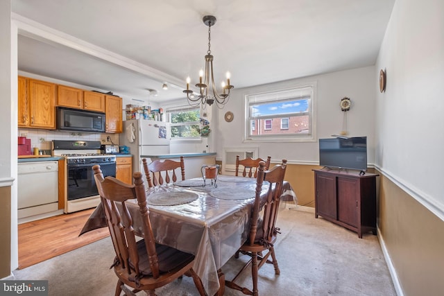 dining space with light hardwood / wood-style floors and a chandelier