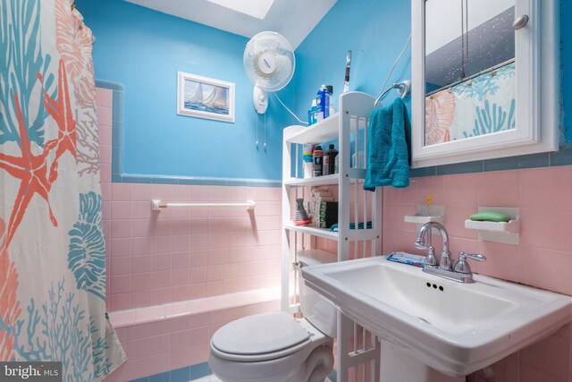 full bathroom with tasteful backsplash, sink, tile walls, shower / tub combo with curtain, and toilet