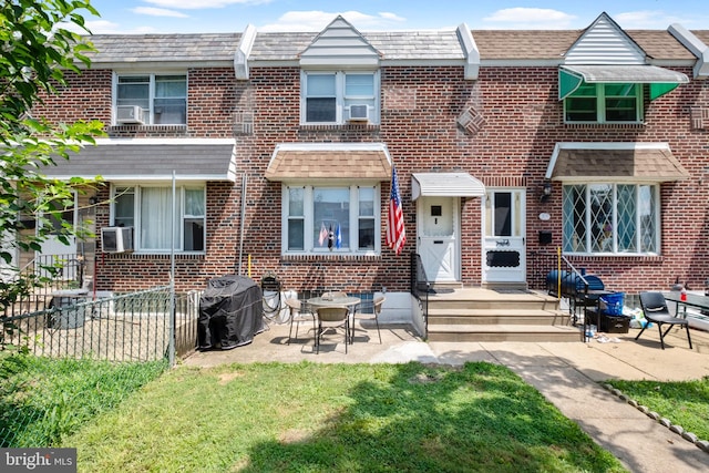 multi unit property featuring cooling unit, a patio area, and a front yard