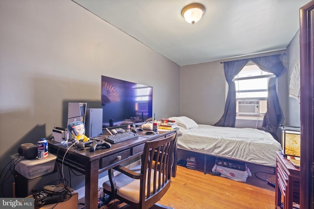 bedroom with cooling unit and light wood-type flooring