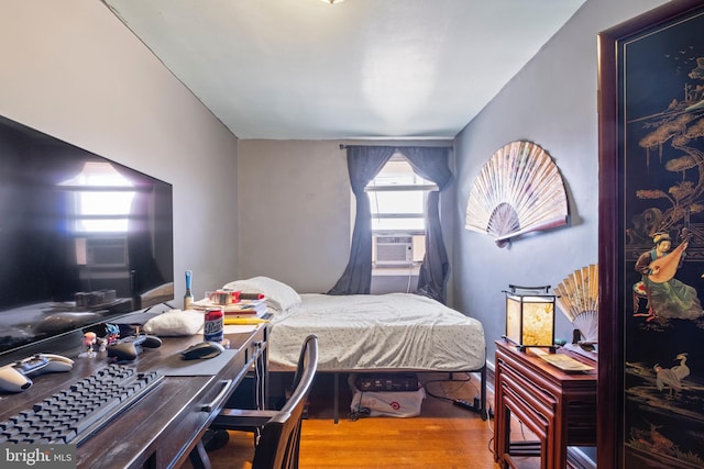 bedroom with light hardwood / wood-style flooring and cooling unit