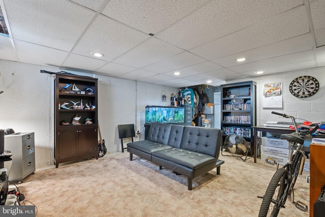 living room featuring a drop ceiling and light carpet