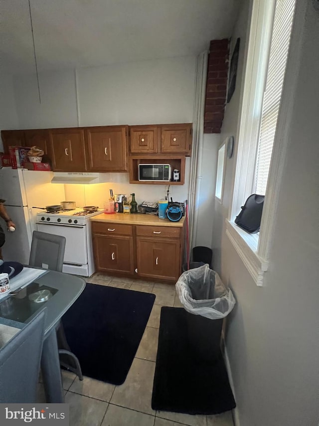 kitchen featuring white appliances and light tile patterned flooring