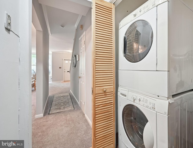 clothes washing area featuring stacked washer / dryer, crown molding, and light carpet