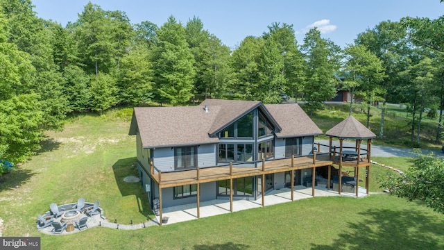 back of house featuring a lawn, roof with shingles, a deck, a gazebo, and a patio area