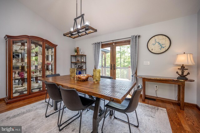 dining room with vaulted ceiling, french doors, and hardwood / wood-style floors