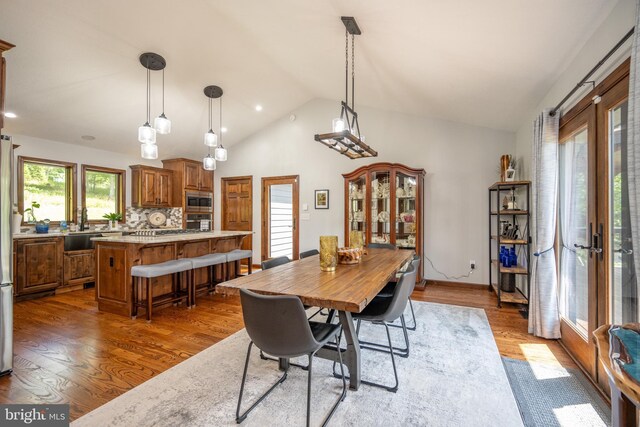 dining space with wood-type flooring and high vaulted ceiling