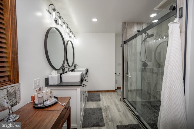 bathroom with walk in shower, hardwood / wood-style floors, and vanity