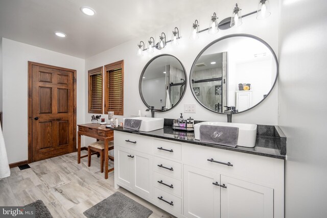 bathroom with double vanity and wood-type flooring