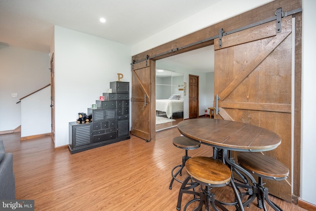 dining room featuring hardwood / wood-style floors and a barn door