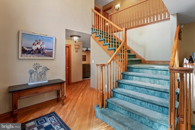 stairs featuring a high ceiling and wood-type flooring