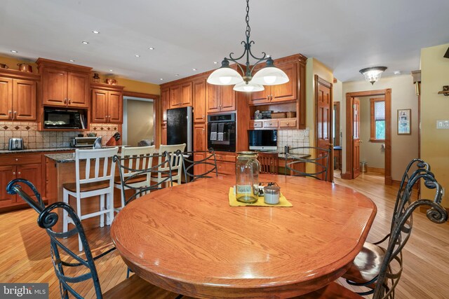 dining room with an inviting chandelier and light wood-type flooring