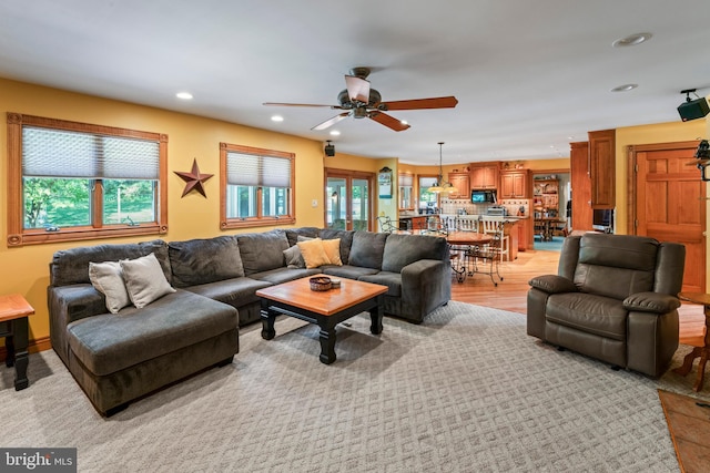 living room with ceiling fan and light colored carpet