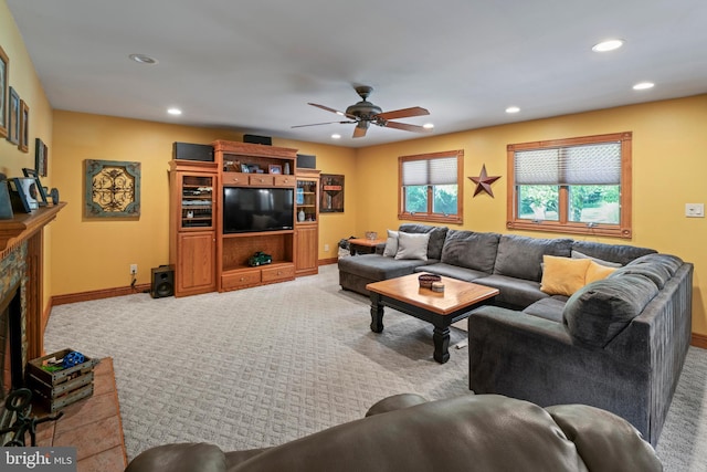 carpeted living room featuring a fireplace and ceiling fan