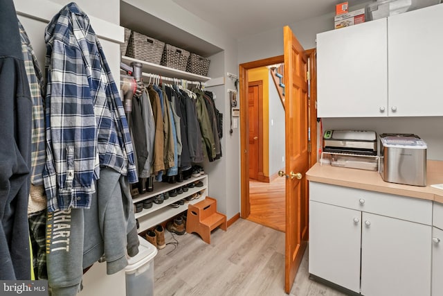 walk in closet with light wood-type flooring