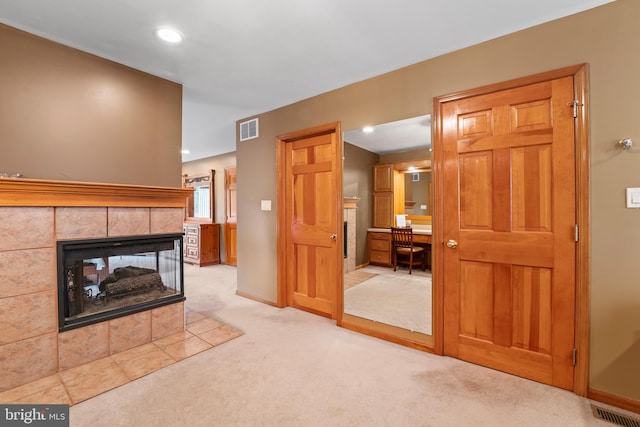 carpeted living room with a tile fireplace