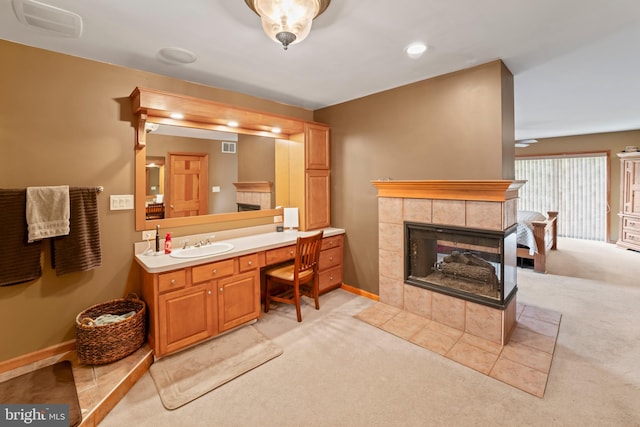 bathroom with ceiling fan, vanity, and a fireplace