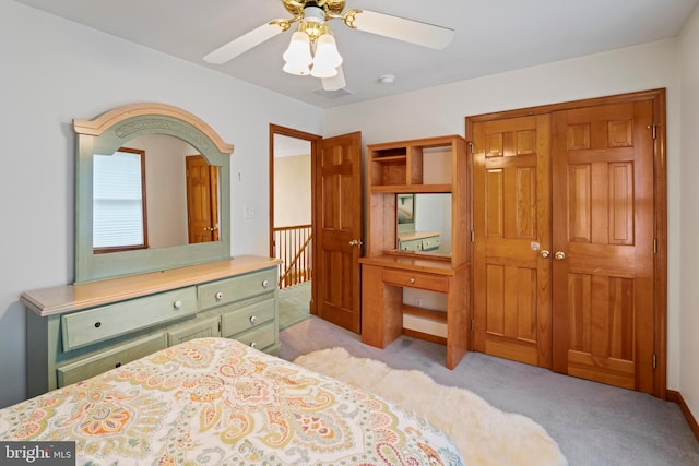 carpeted bedroom featuring ceiling fan and a closet