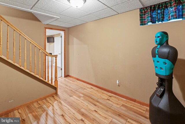 interior space with hardwood / wood-style floors and a drop ceiling