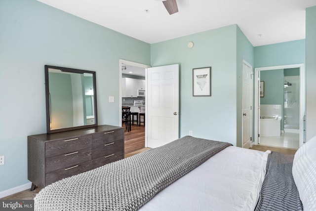 bedroom with ceiling fan, connected bathroom, and wood-type flooring