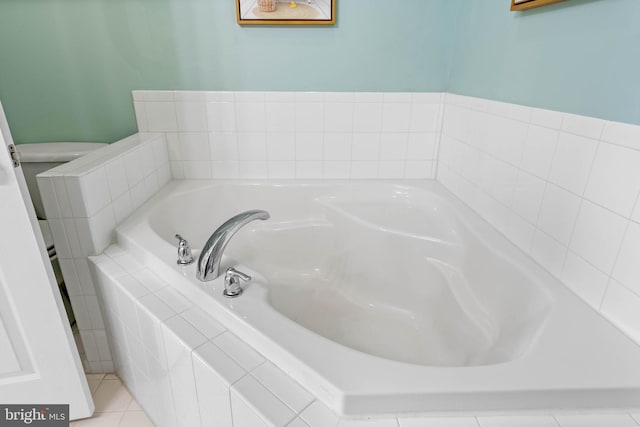 bathroom with a relaxing tiled tub and tile patterned floors