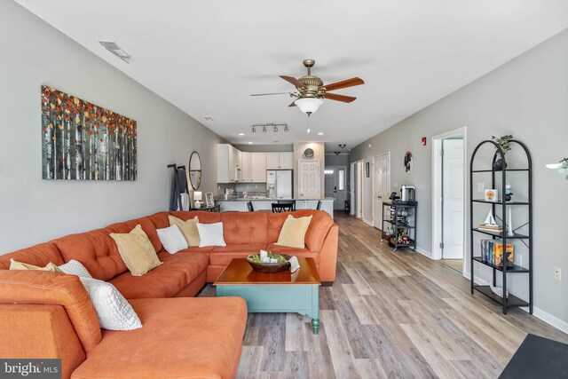 living room with light wood-type flooring and ceiling fan