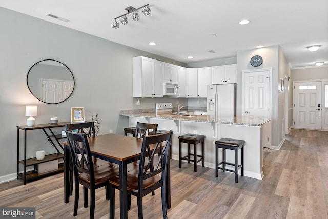 dining room featuring sink and light wood-type flooring