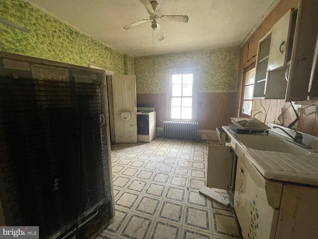 kitchen featuring ceiling fan, tile countertops, radiator, and light tile patterned floors