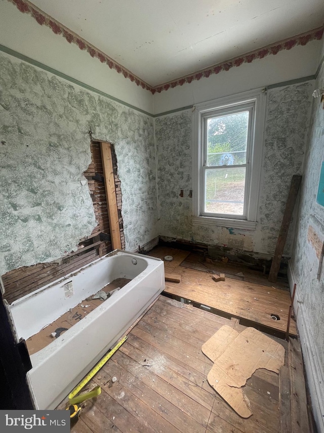 bathroom with wood-type flooring and a bathtub