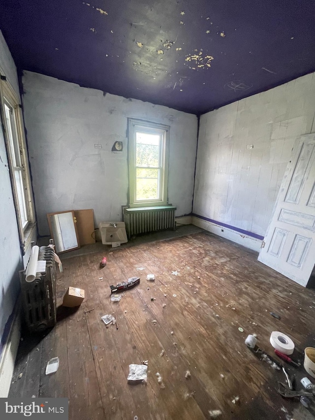 interior space with radiator heating unit and hardwood / wood-style flooring