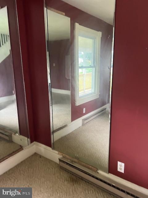 hall featuring carpet flooring and a baseboard heating unit