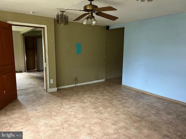 tiled empty room featuring ceiling fan