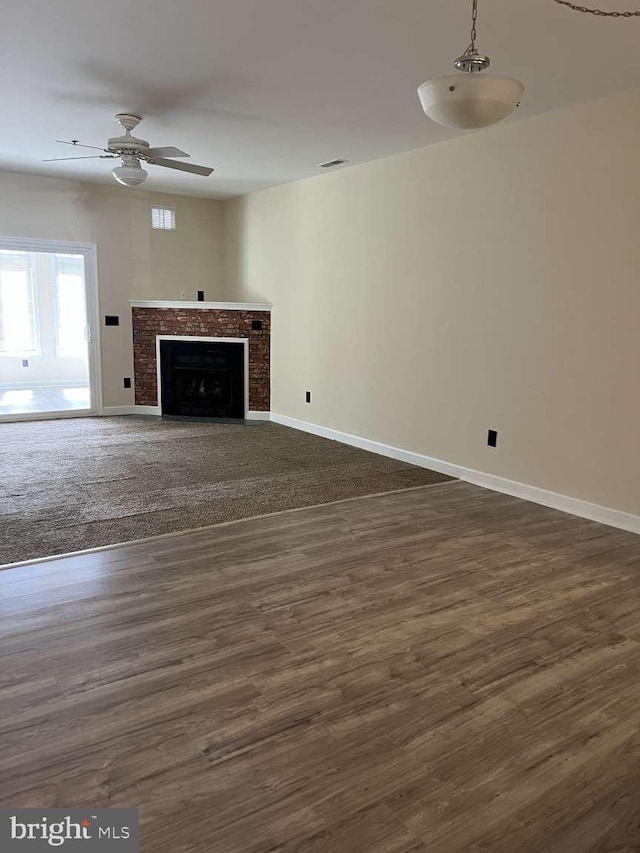 unfurnished living room featuring ceiling fan and dark hardwood / wood-style floors