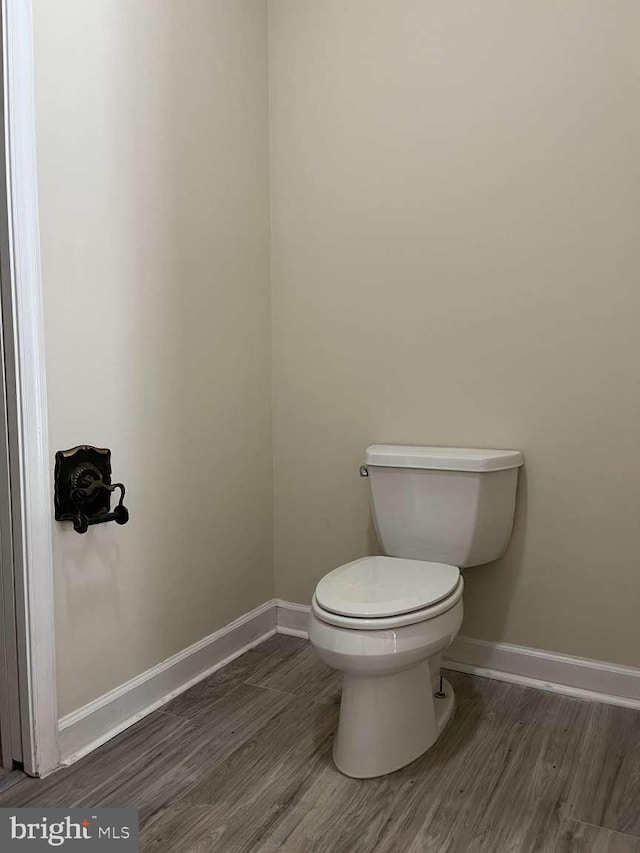 bathroom with wood-type flooring and toilet