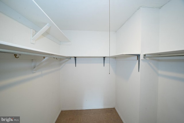 walk in closet featuring dark parquet floors