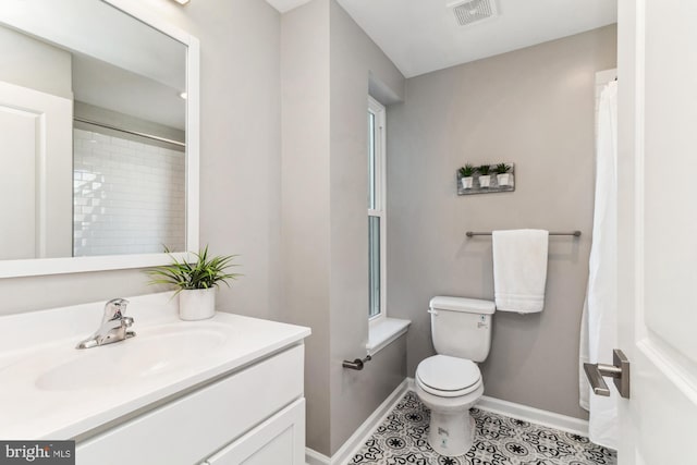 bathroom featuring vanity, toilet, and tile patterned flooring