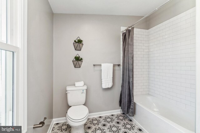 bathroom with shower / bath combo with shower curtain, toilet, and tile patterned floors