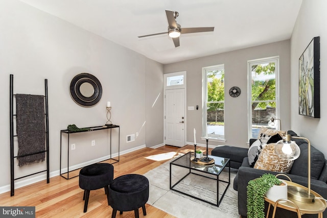 living room featuring light wood-type flooring and ceiling fan