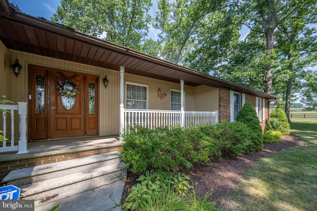 view of exterior entry featuring covered porch