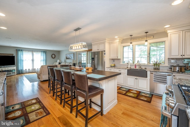 kitchen featuring sink, appliances with stainless steel finishes, plenty of natural light, and light hardwood / wood-style floors